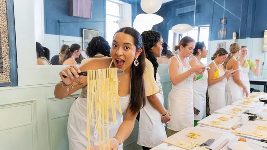 Participants making pasta at a cooking class in Rome.
