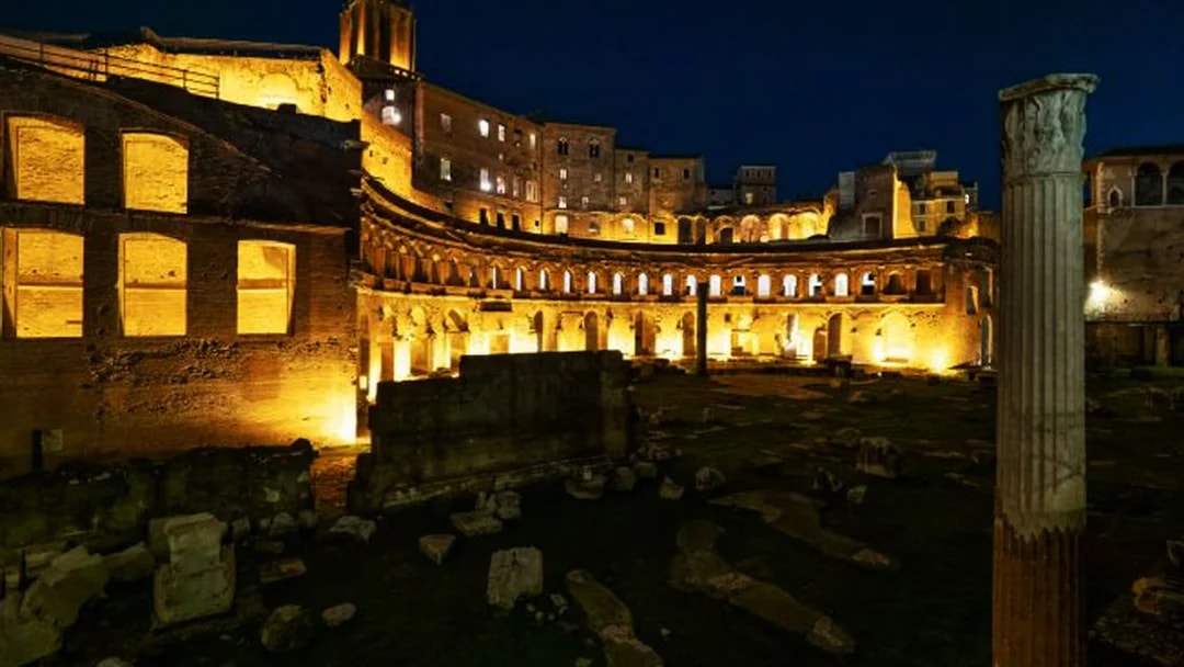 Ancient ruins illuminated at night in Rome, Italy.