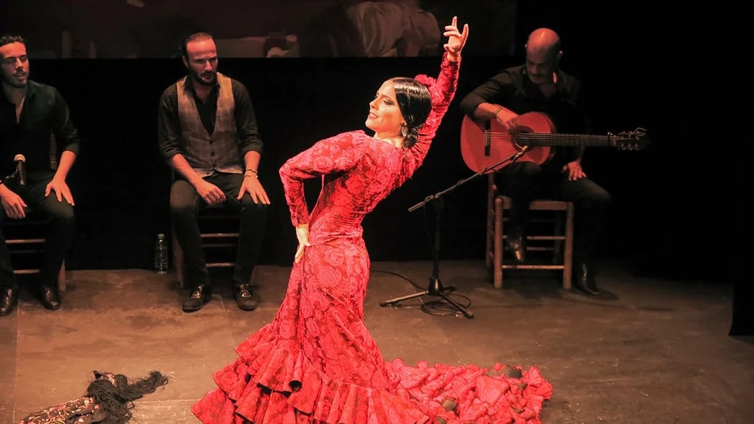 Flamenco dancer performing at Teatro Flamenco Triana with musicians.