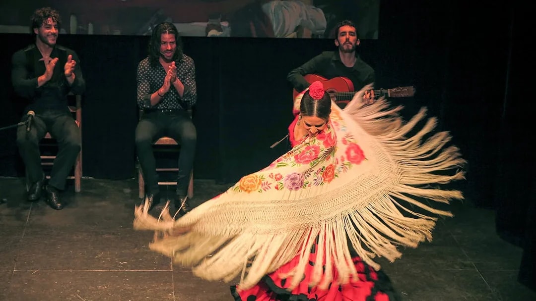 Flamenco dancer performing with musicians at Teatro Flamenco Triana.