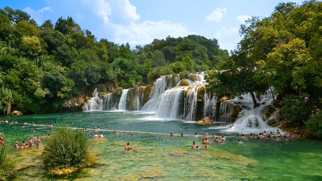 Visitors swimming near waterfalls at Krka National Park, Croatia.