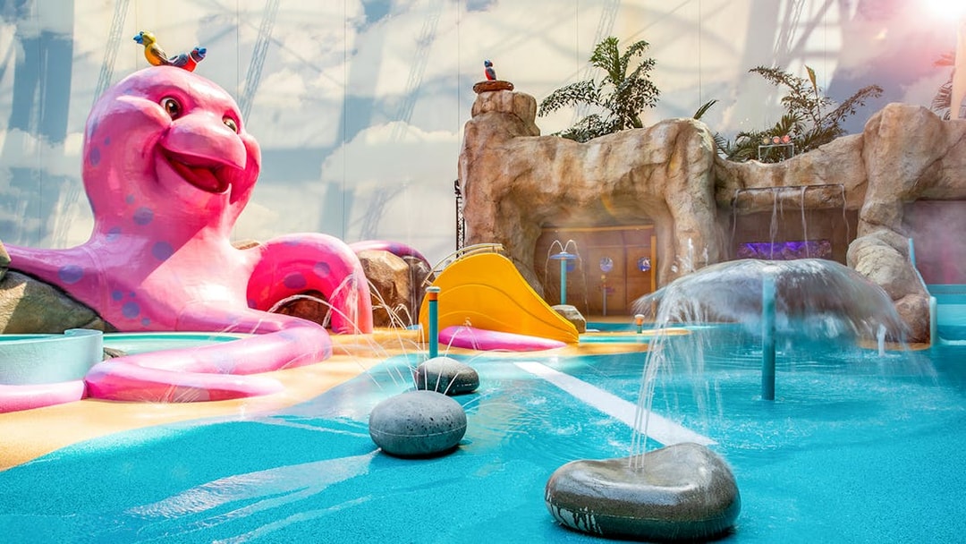 Colorful water play area with slides and fountains at Tropical Islands Resort.