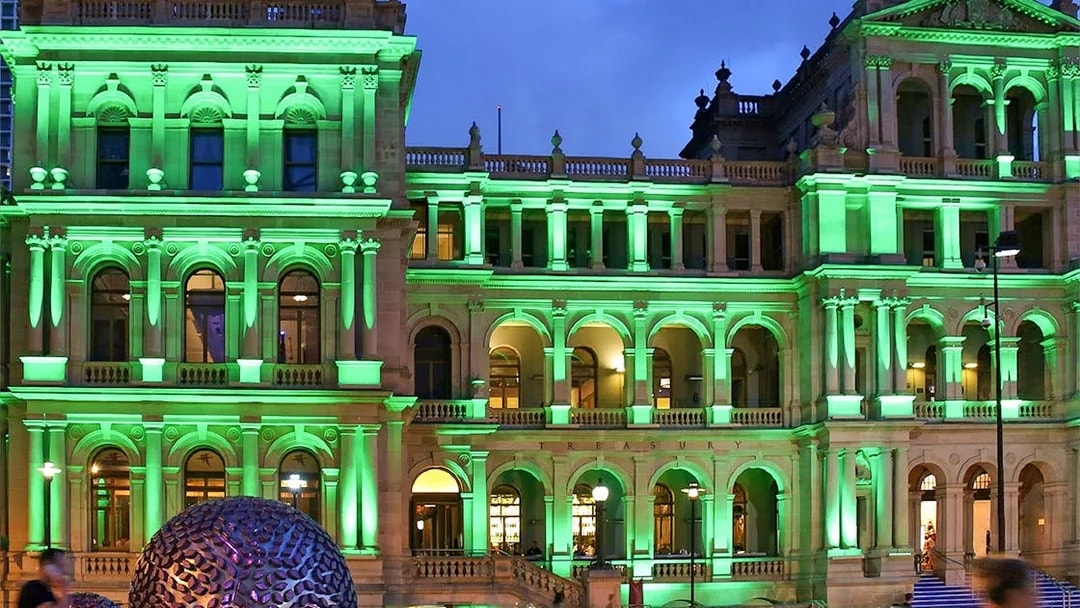 Brisbane Treasury Building illuminated at night, related to true crime stories tour.
