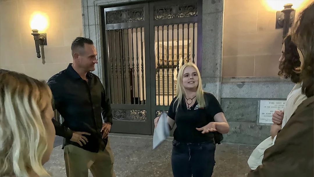 Tour guide discussing Brisbane's true crime stories with a group outside a historic building.