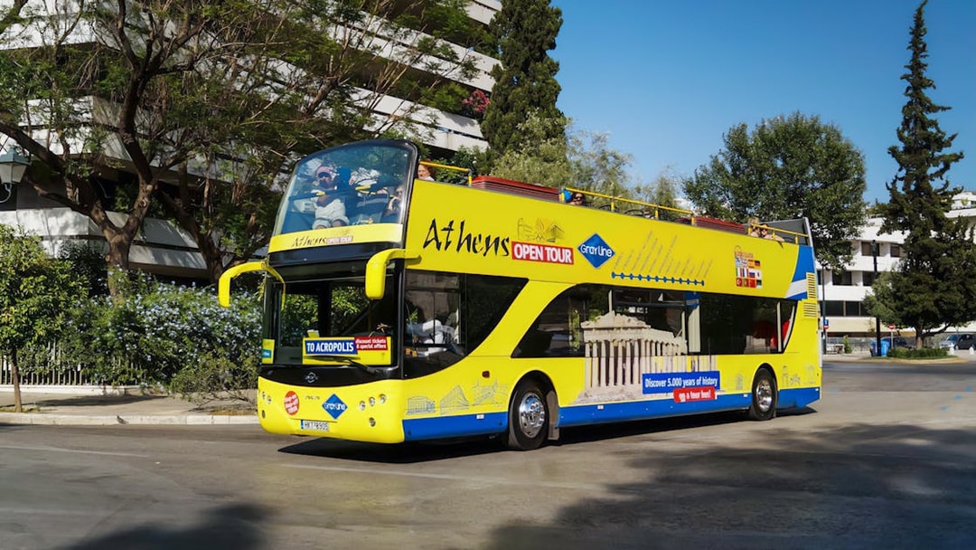 Athens open-top tour bus on city street, part of Turbopass Athens City Pass.