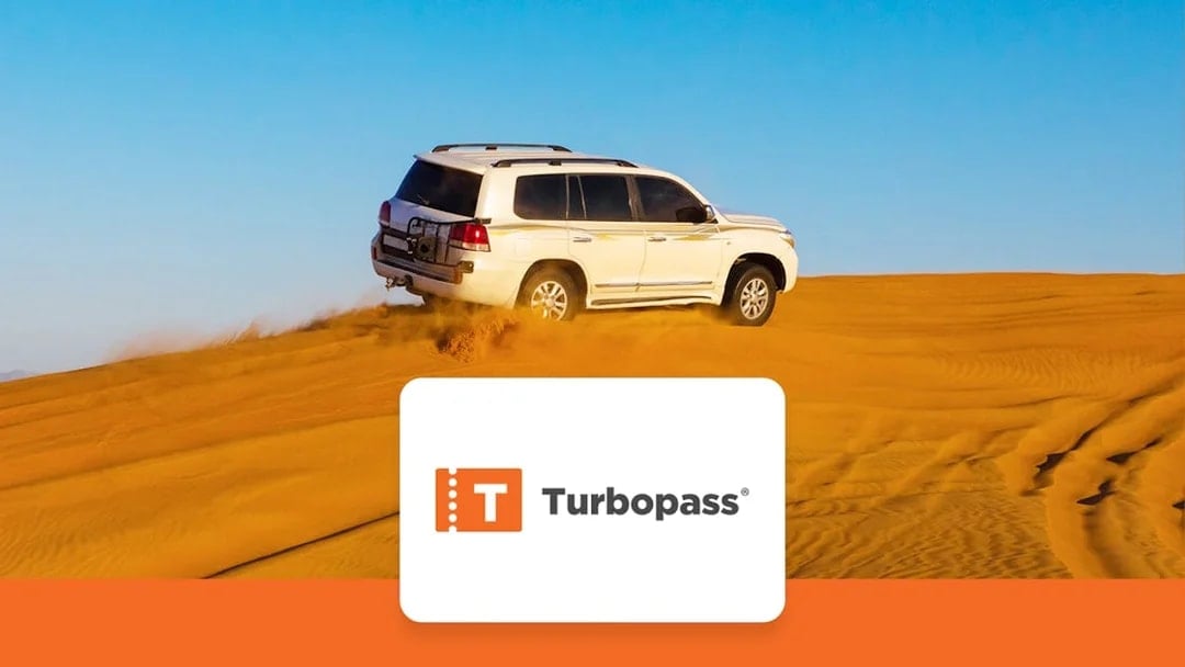SUV driving on Dubai desert dunes, part of Dubai City Pass experience.