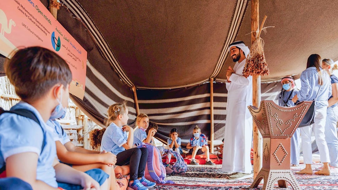 Children learning in a traditional tent during a cultural tour in Dubai.