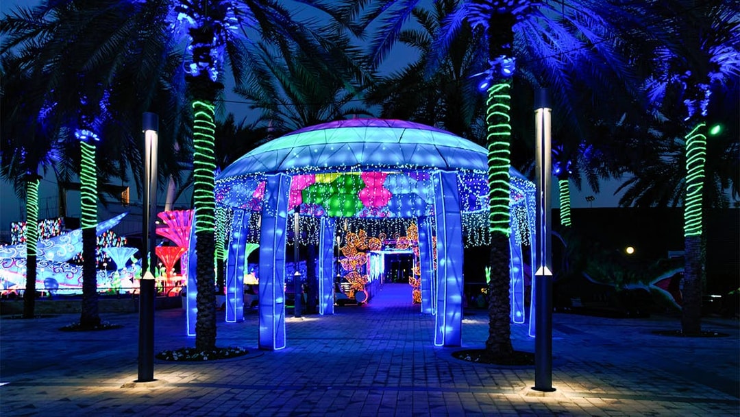 Illuminated pavilion and palm trees at Glow Garden, Dubai.
