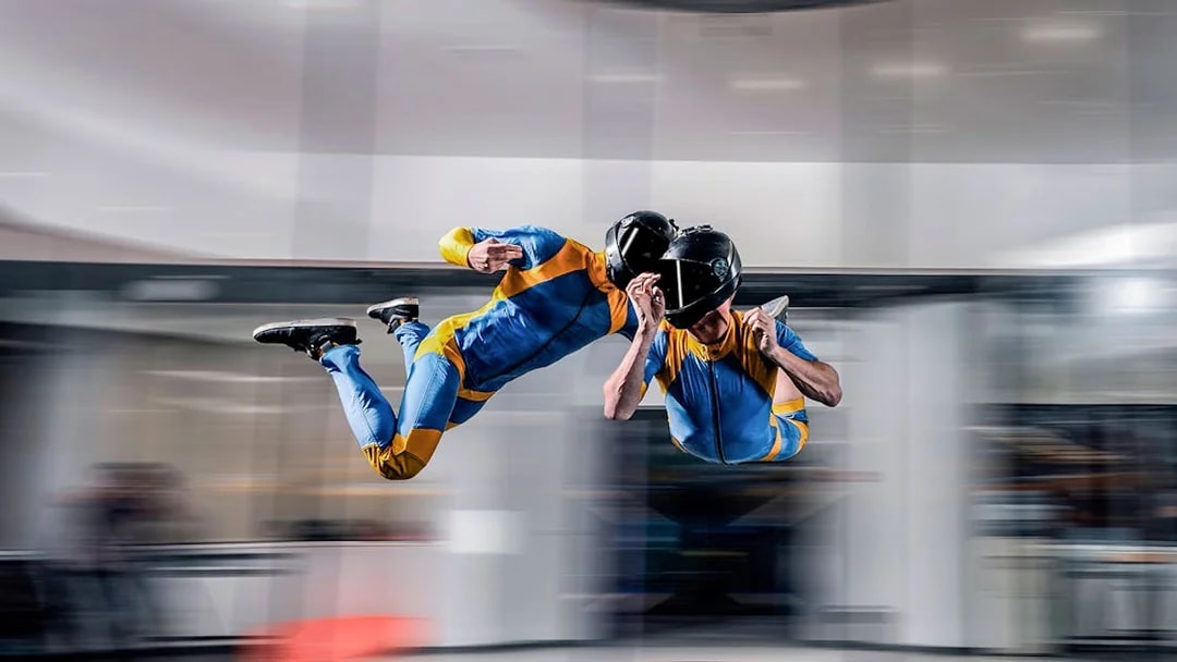 Indoor skydiving experience in Dubai with two people in flight suits.