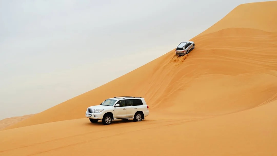 SUVs driving on sand dunes during a desert safari in Dubai.