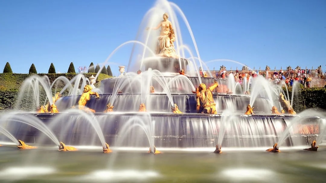 Fountain with golden statues in the Garden of the Palace of Versailles.