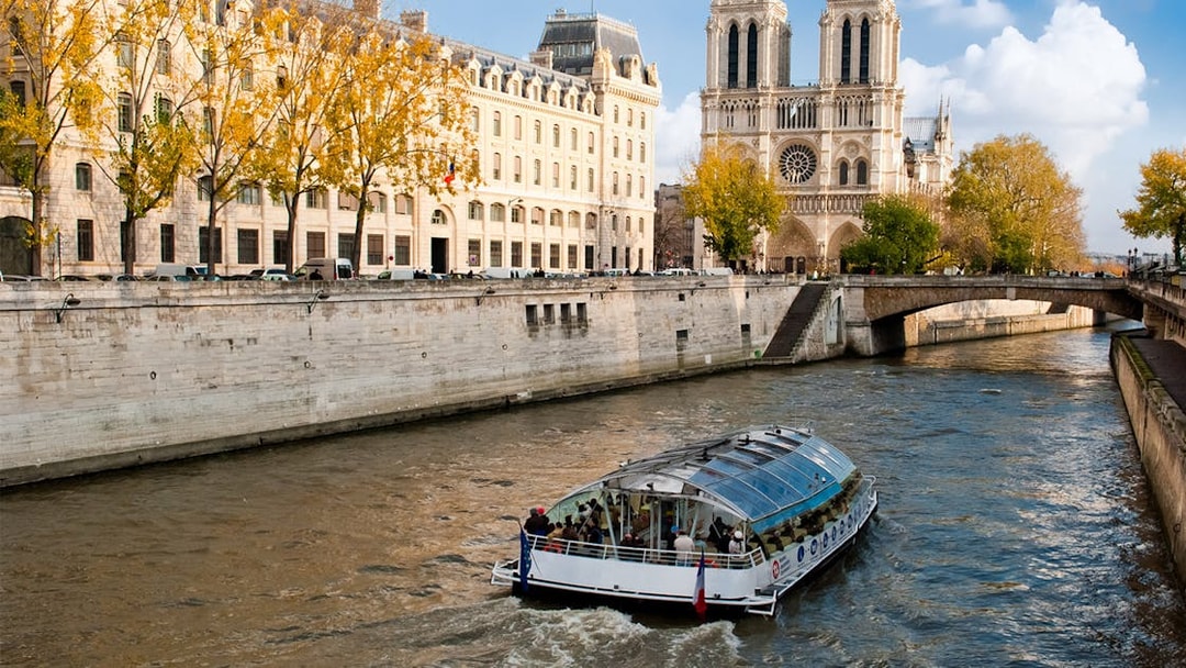 Seine River cruise boat near Notre-Dame Cathedral in Paris.
