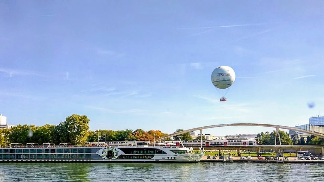 Hot air balloon over Seine River near bridge in Paris.