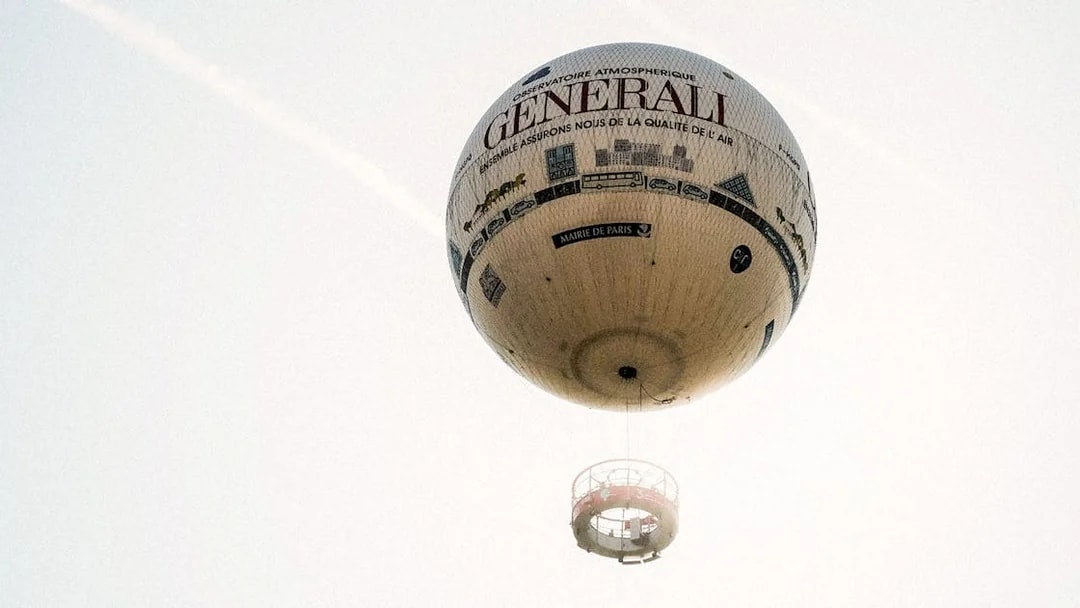 Hot air balloon floating in Paris sky with "Generali" branding.