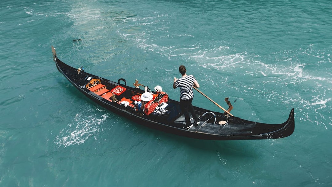 Gondola on Venice canal with passengers, part of Venice Turbopass experience.