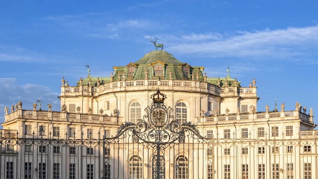 Hunting Lodge of Stupinigi in Turin, Italy, with ornate gate and blue sky.