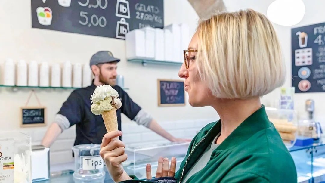 Woman enjoying gelato in a Rome gelateria during a food tour.