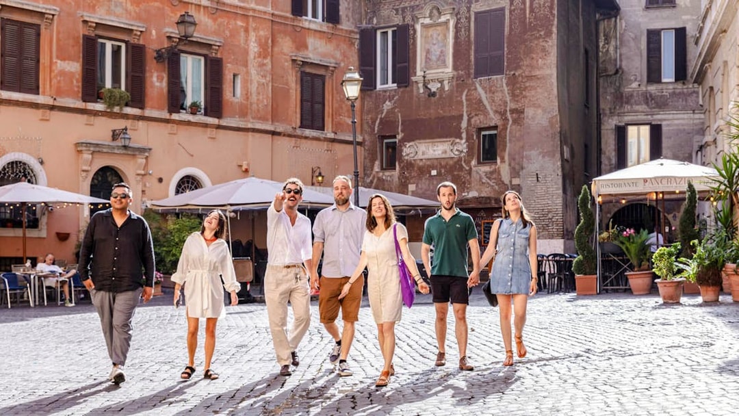 Group walking through a historic square in Rome on a guided food tour.