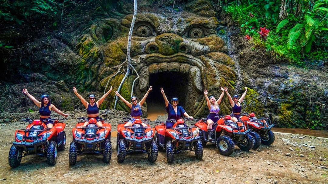 ATV riders in front of Gorilla Face cave entrance in Ubud jungle.