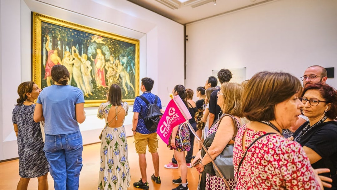 Visitors viewing Botticelli's "Primavera" on a guided tour at the Uffizi Gallery, Florence.