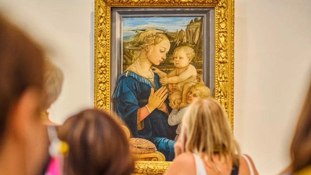 Visitors viewing a Botticelli painting in the Uffizi Gallery, Florence.