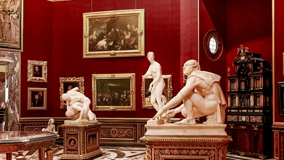Sculptures and paintings in a gallery room at the Uffizi Gallery, Florence.