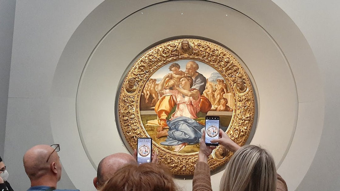 Visitors photographing Michelangelo's Holy Family at Uffizi Gallery, Florence.