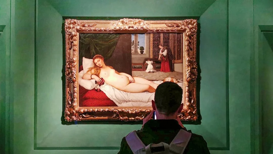 Visitor viewing 'The Venus of Urbino' by Titian at Uffizi Gallery, Florence.