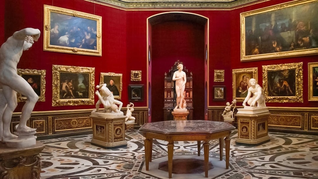 Tourists viewing sculptures and paintings in the Uffizi Gallery, Florence, Italy.