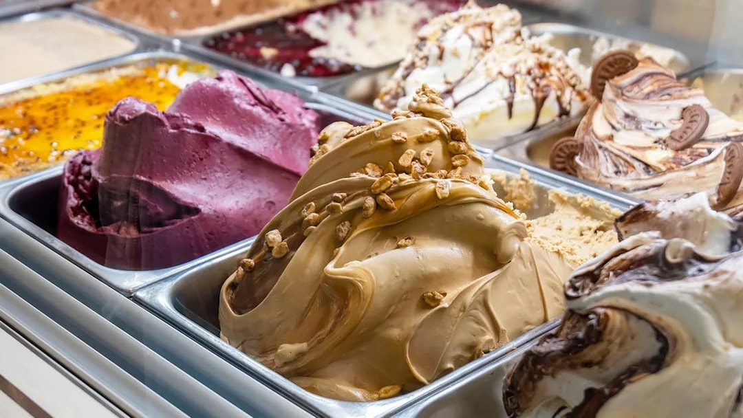 Variety of gelato flavors in a display case, including chocolate and fruit options.
