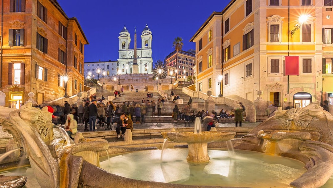 Fountain at Piazza di Spagna with Spanish Steps in Rome at dusk, Italy.
