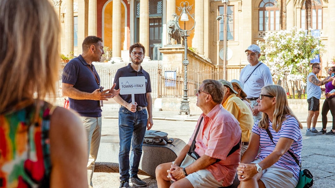 Tour guide leading a group at a historic site in Palermo, Italy, during a UNESCO walking tour.