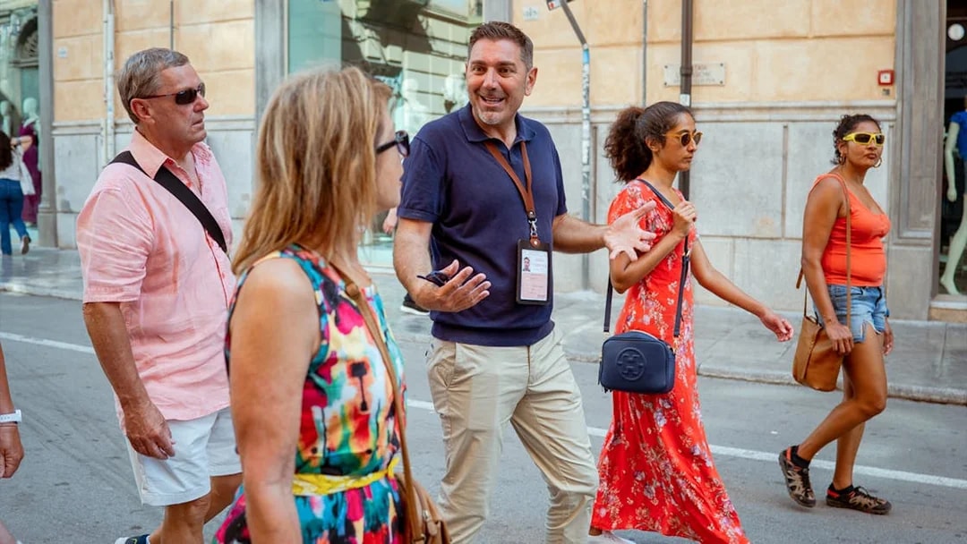 Tour guide leading a group on a walking tour in Palermo, Italy.