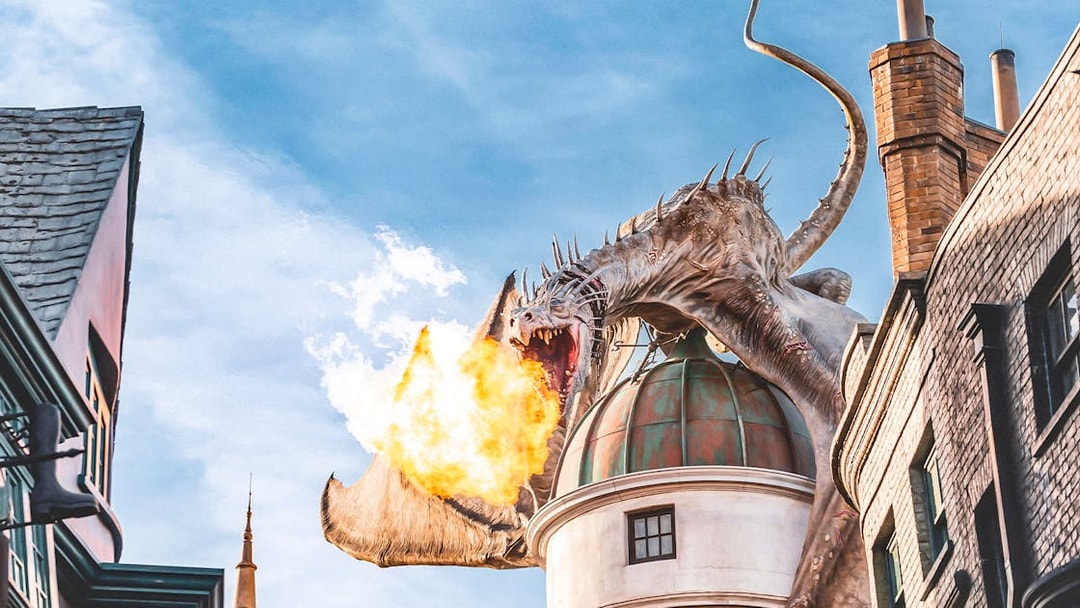 Dragon breathing fire atop a building at Universal Studios Orlando Resort.