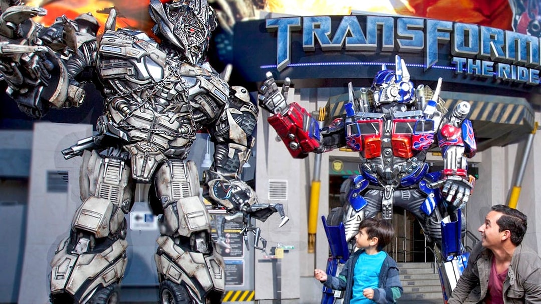 Transformers characters at Universal Studios Hollywood with visitors in front of the ride entrance.