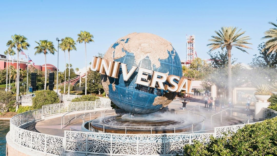 Universal globe at entrance of Universal Studios Resort, Orlando, Florida with palm trees.