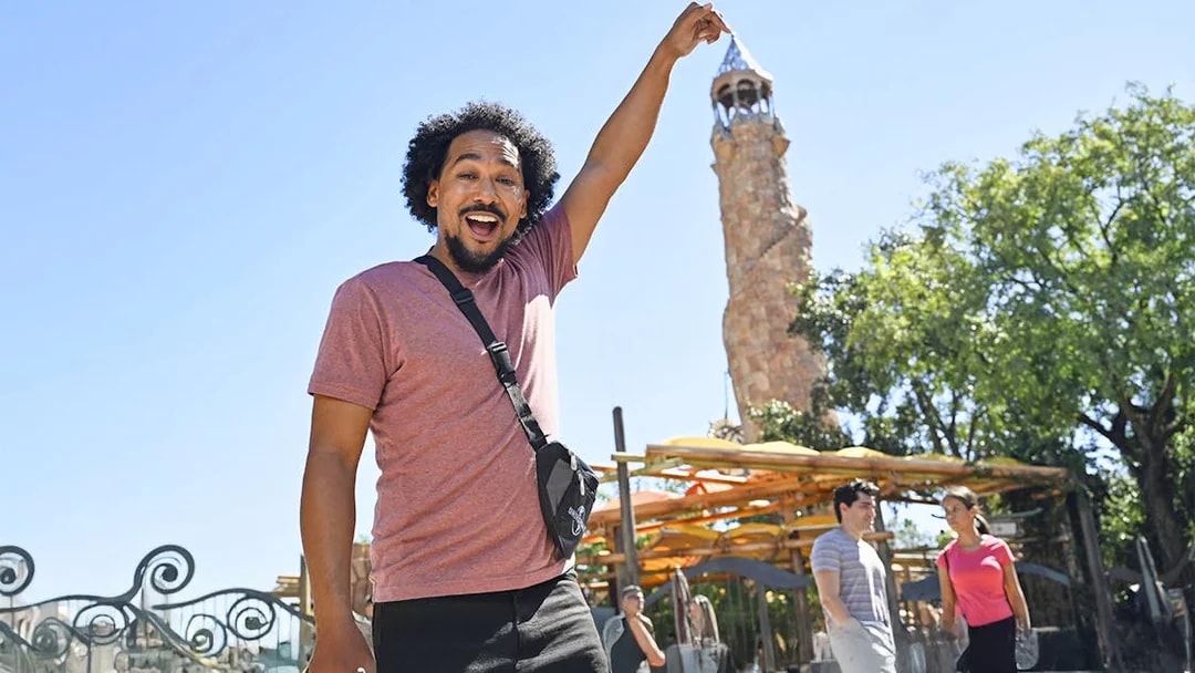 Man posing with Islands of Adventure tower at Universal Studios Orlando.