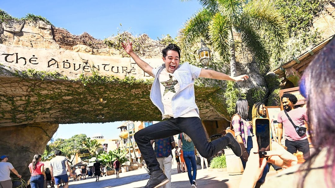 Man jumping in front of Adventure Island entrance at Universal Studios Orlando.