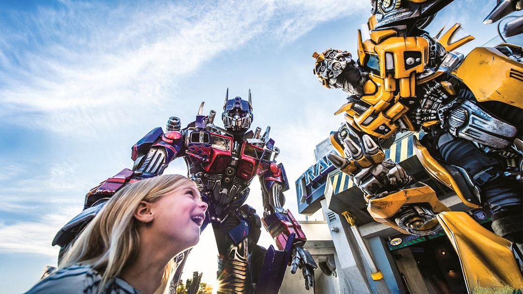 Little girl looking up at Transformers characters at Universal Studios Orlando.