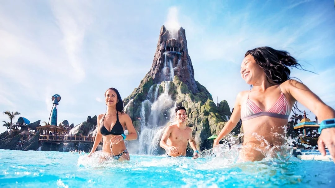 Guests enjoying the waterpark at Universal Studios Resort, Orlando, with a volcano backdrop.