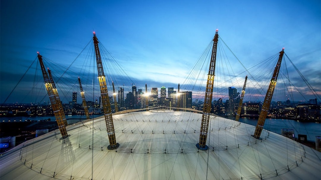 O2 Arena roof with city skyline at twilight, London.