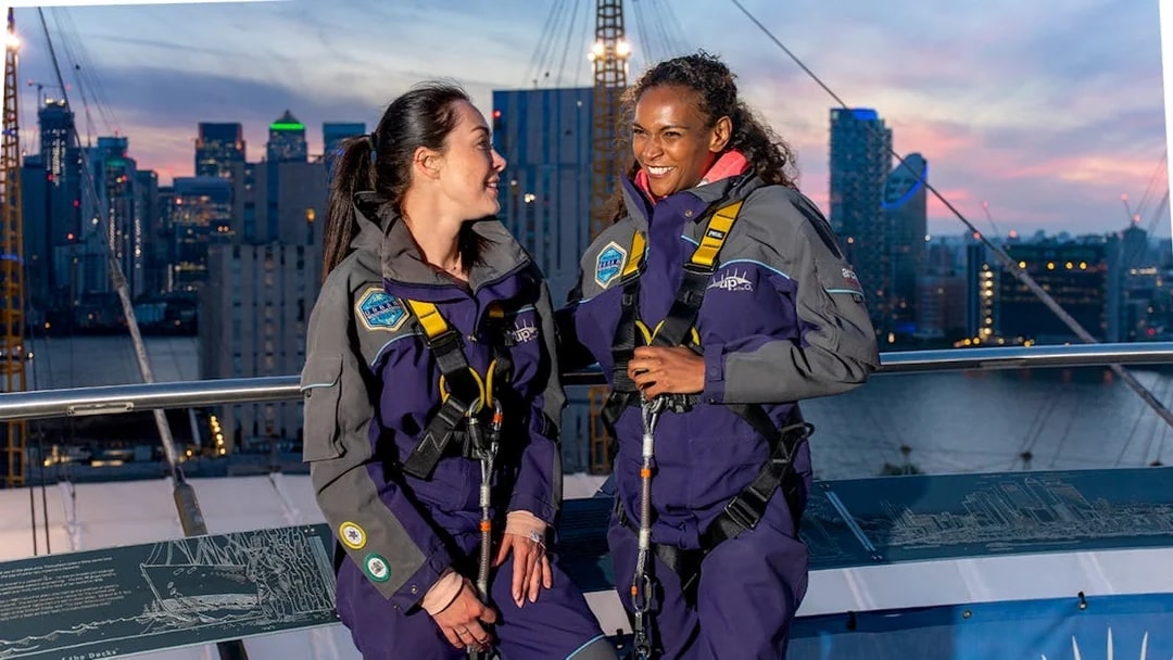 Guests enjoying the O2 rooftop experience at twilight with city skyline in the background.