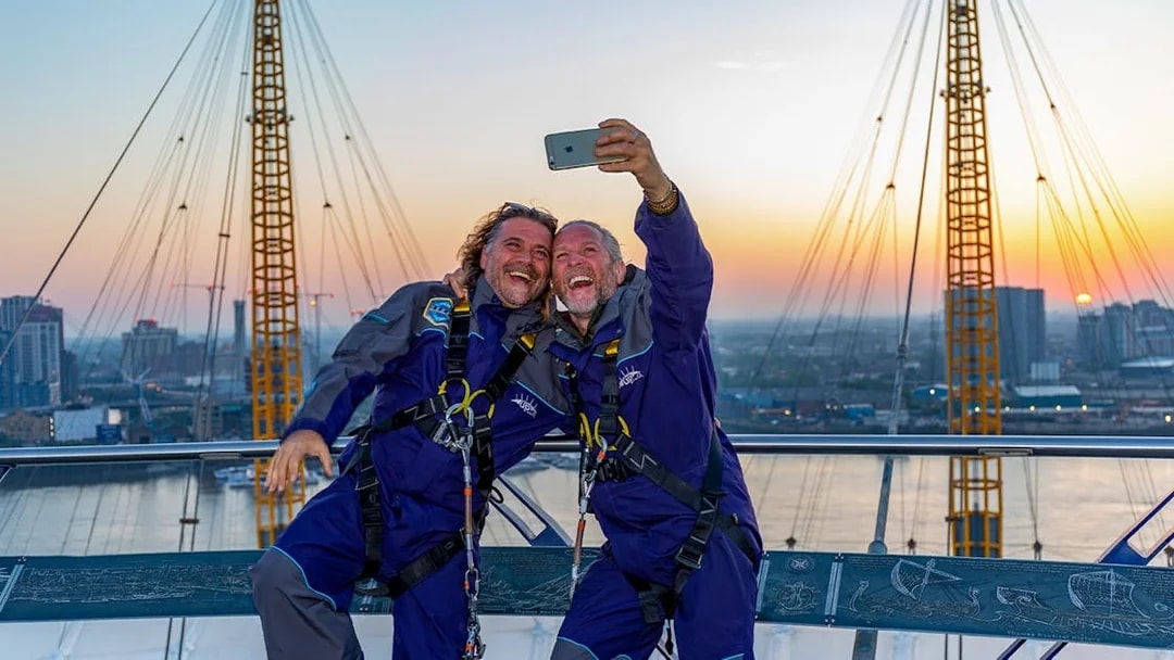 Guests taking a selfie on the O2 roof at sunset in London.