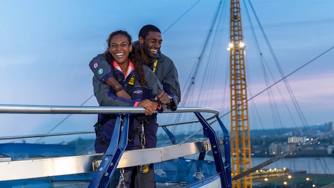 Guests enjoying the view from the O2 rooftop at twilight in London.