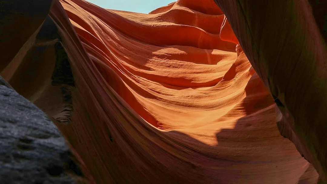 Upper Antelope Canyon's smooth, wave-like sandstone formations illuminated by sunlight.