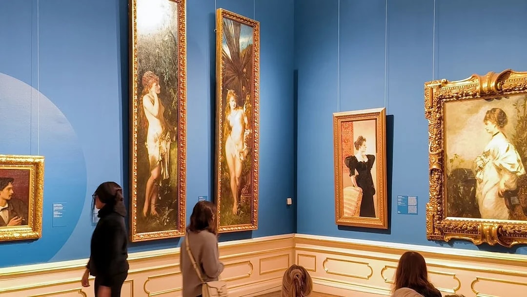 Visitors viewing paintings on a guided tour at Upper Belvedere Palace art gallery.