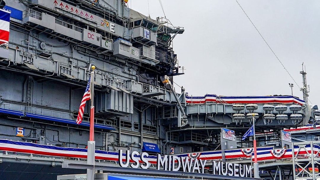 USS Midway Museum exterior with American flags and naval decorations.