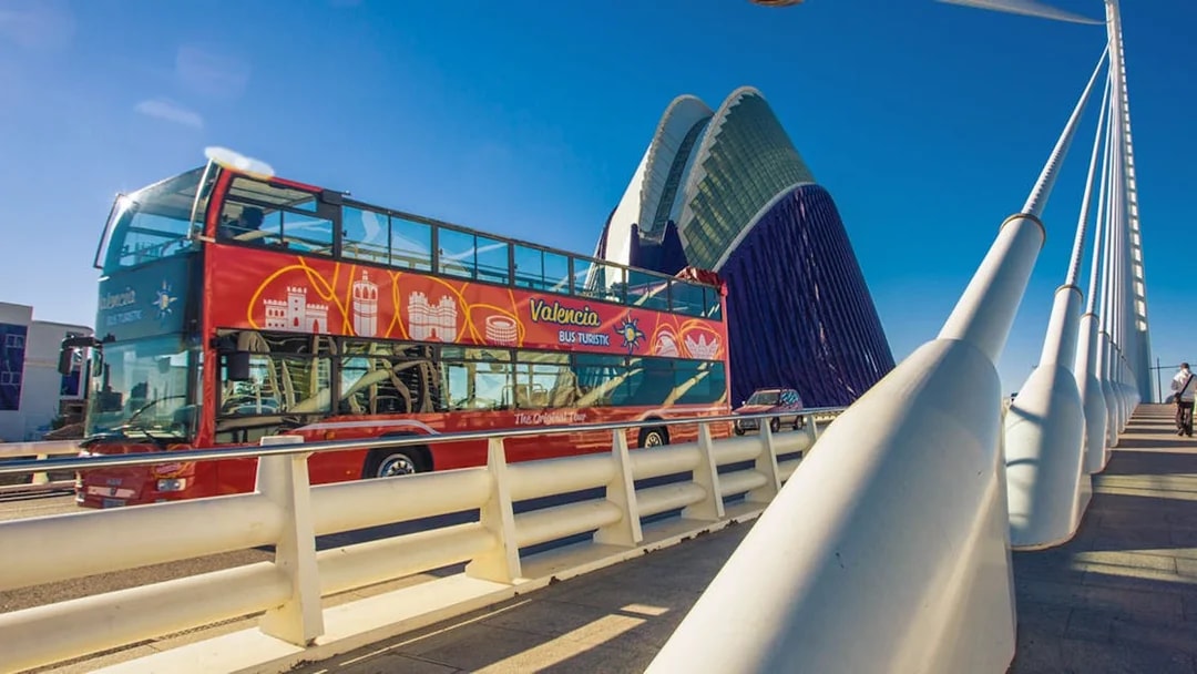 Valencia Hop On Hop Off bus crossing a modern bridge near the City of Arts and Sciences.