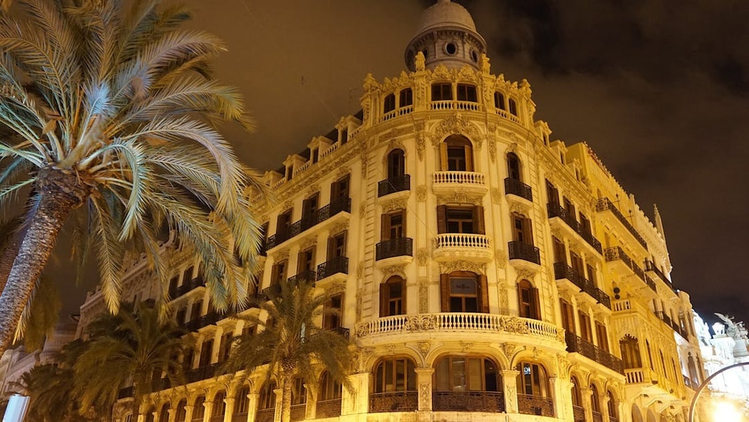 Valencia historic building with palm trees at night on self-guided audio tour.