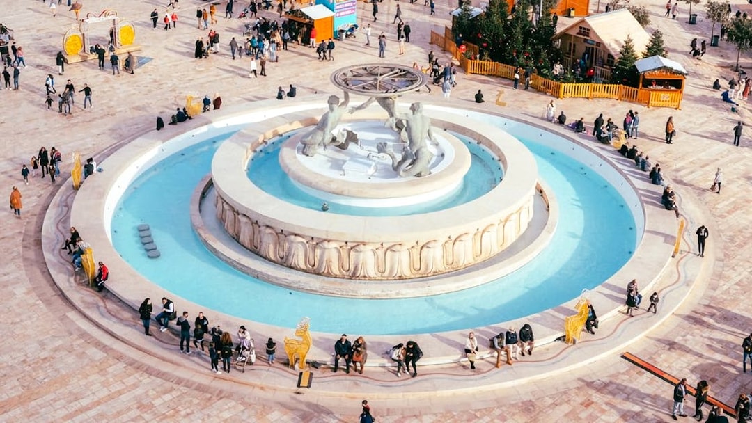 Aerial view of Triton Fountain in Valletta, Malta, with people gathered around.